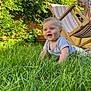 baby, blue_eyes, child, crawling, daylight, deck_chair, garden, grass, greenery, happy, nature, outdoor, person, playful, short_sleeves, smiling, summer, sunlight, toddler, wooden_furniture