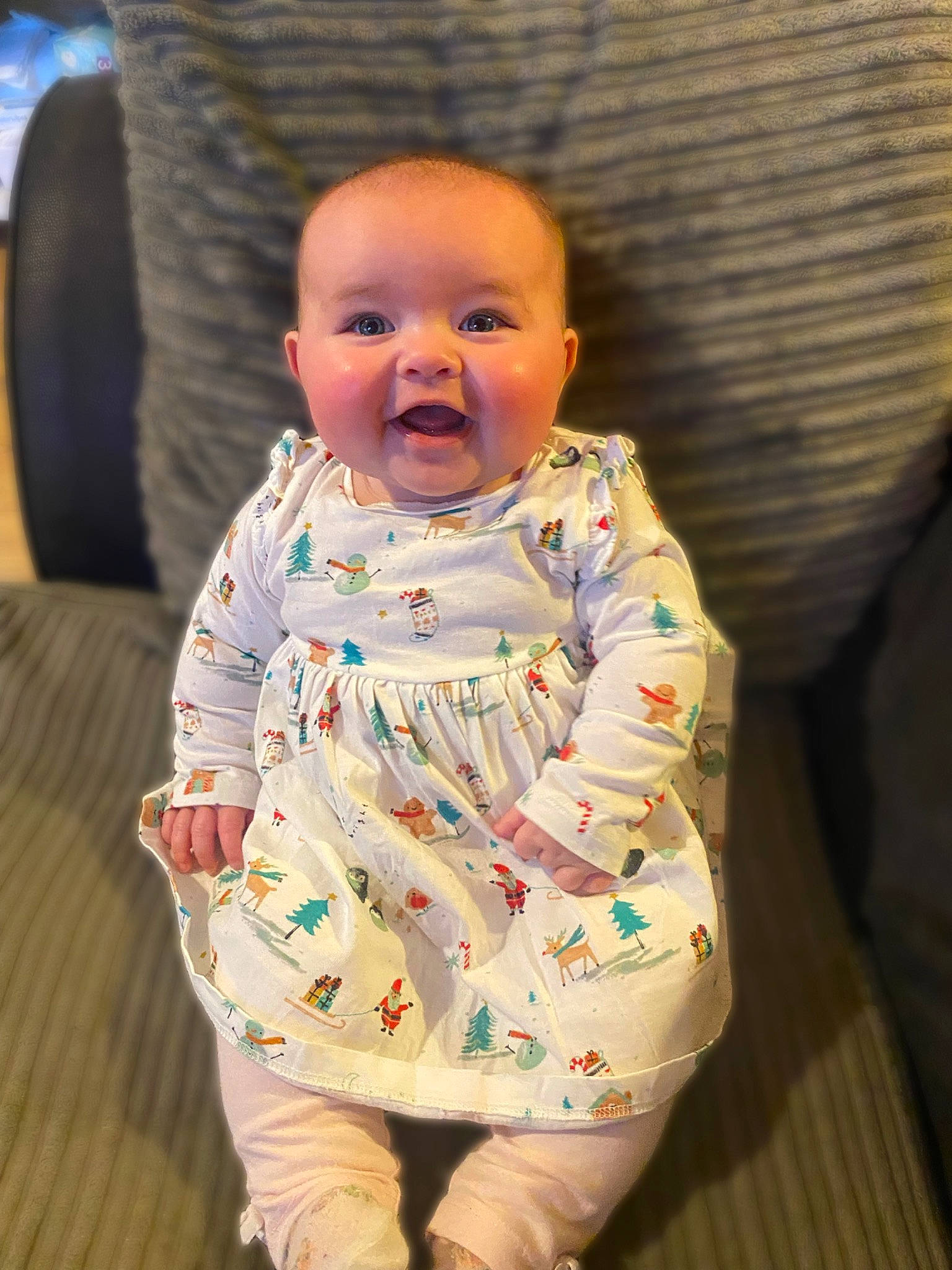 Lydia is registered to the contest to win money with this photo: baby, baby_toddler_clothing, cheek, child, comfort, dress, eye, flooring, fun, happy, iris, pattern, person, room, sitting, skin, sleeve, smile, t_shirt, toddler