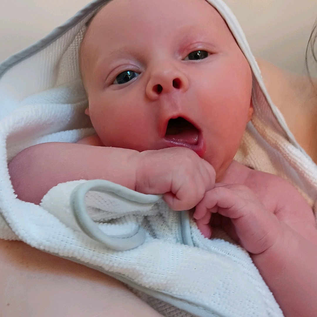 Zevran is registered to the contest to win money with this photo: baby, blanket, bodypart, bonnet, clothing, diaper, face, finger, hand, hat, head, newborn, person, photography, portrait, towel, yawning