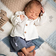 Iroh is registered to the contest to win money with this photo: newborn, baby, sleeping, infant, blanket, knitted, animal_pattern, lion, tiger, clothing, white_shirt, blue_shorts, barefoot, peaceful, cute, soft_texture, portrait, indoors, resting, child