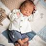 newborn, baby, sleeping, infant, blanket, knitted, animal_pattern, lion, tiger, clothing, white_shirt, blue_shorts, barefoot, peaceful, cute, soft_texture, portrait, indoors, resting, child