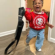 Khmyiah joined the competition — help win amazing prizes! child, toddler, indoor, running, red_sweatshirt, hello_kitty, blue_pants, white_shoes, headband, black_strap, smiling, happy, curly_hair, wooden_floor, doorway, wall, person, clothing, playful, motion_blur