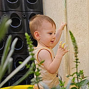 Eden participe au concours pour gagner de l'argent avec cette photo : casual_clothing, child, curious, daylight, exploration, expression, fingers, greenery, messy, nature, outdoor, paint, plants, playtime, side_profile, summer, toddler, wall, yellow_pool, young_child
