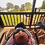 Brandon is registered to the contest to win money with this photo: baby, person, lap, porch, outdoor, grass, tree, chair, drink, railing, car, jeans, shoe, shirt, hand, head, relaxation, daylight, candid, blanket