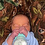 Brandon joined the competition — help win amazing prizes! baby, newborn, bottle, milk, hands, face, blanket, pattern, deer, animal_print, sleeping, infant, clothing, blue_sleeves, resting, cute, small_hands, cozy, portrait, indoors