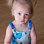 blue_and_white, blue_bows, casual_clothing, child, curious_expression, cute, dress, floral_pattern, girl, indoor, innocent, looking_up, person, pigtails, portrait, small_hands, standing, toddler, wooden_floor, young_child