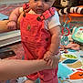 Rhaelynn is registered to the contest to win money with this photo: baby, child, overalls, pink_clothing, play_mat, indoor, carpet, toy, hands, supporting, curious, person, home, foot, furniture, colorful, soft_lighting, portrait, infant, cute