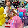 bubbles, bunny_ears, carseat, child, countertop, curious, cute, easter, food, holiday, indoor, kitchen, person, pink, plastic_egg, playtime, snacks, toddler, toys, yellow