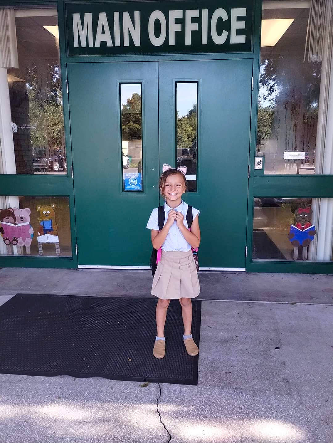 Vanessa is registered to the contest to win money with this photo: advertising, building, city, door, electric_blue, eyewear, facade, flooring, fun, human_leg, joy, leisure, logo, pedestrian, person, road, standing, street, tourism, travel