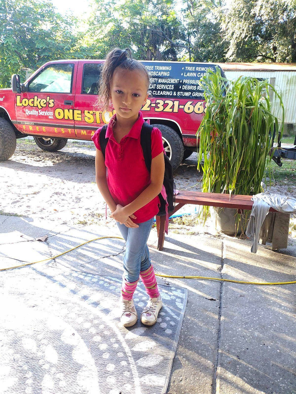 Vanessa is registered to the contest to win money with this photo: asphalt, automotive_tire, bumper, car, city, fun, grass, leisure, motor_vehicle, person, plant, recreation, road, road_surface, tire, toddler, travel, tree, vehicle, vehicle_door