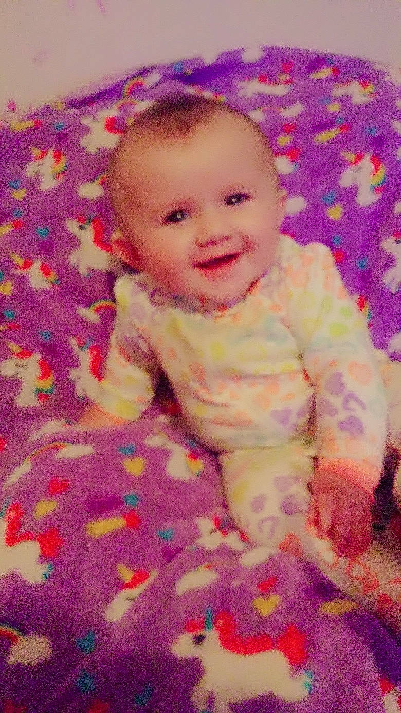 Kadence is registered to the contest to win money with this photo: baby, blanket, cheek, child, eye, face, head, iris, joy, lip, mouth, nose, person, pink, skin, smile, textile, toddler