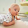Justin is registered to the contest to win money with this photo: baby, infant, child, blonde_hair, blue_eyes, tshirt, mickey_mouse, play_mat, floor, curious, cute, indoor, skin, face, hand, arm, young_child, casual_clothing, portrait, laying_down