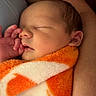 Jackson joined the competition — help win amazing prizes! adult_arm, baby, blanket, close_up, cozy, cuddling, eyes_closed, face, family, finger, hand, indoors, infant, newborn, orange_blanket, peaceful, portrait, sleeping, warm_lighting, white_blanket