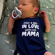 Jackson is registered to the contest to win money with this photo: arms, baby, baby_blanket, bassinet, child, crib, indoors, infant, legs, lying_down, mama, newborn, onesie, pacifier, patterned_bedding, portrait, safe_sleeping_area, shirt, sleepy, text_on_clothing