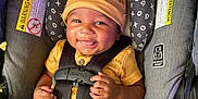 Uriah joined the competition — help win amazing prizes! baby, black_straps, blanket, car_seat, child, cute, face, gray_seat, happy, hat, indoor, infant, pacifier, person, playful, portrait, safety_harness, seatbelt, smile, yellow_clothing