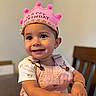 Araceli joined the competition — help win amazing prizes! accessory, apparel, birthday_crown, bracelet, celebration, chair, child, cute, face, happy, indoor, person, pink_overalls, portrait, short_sleeves, smiling, table, toddler, toy, young_child