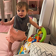 Araceli is registered to the contest to win money with this photo: toddler, child, baby, toy, play, indoor, crib, mat, pink, clothing, bib, furniture, air_purifier, room, balance, curious, person, young_child, home, soft