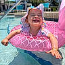 toddler, child, pool, water, inflatable_ring, pink, hat, sun_hat, smiling, happy, summer, outdoor, daylight, swimming_pool, baby, floating, fun, vacation, sunshine, playful