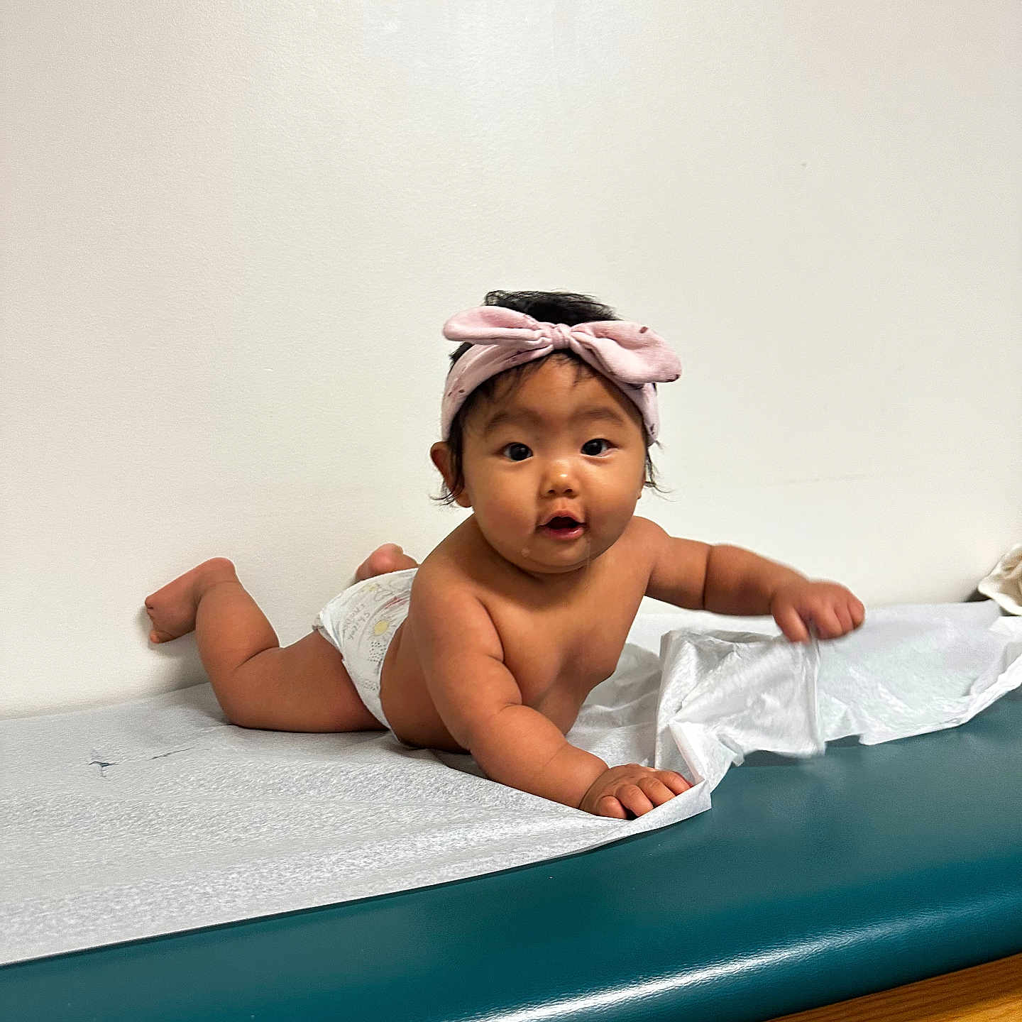 Olivee Din Lian joined the competition — help win amazing prizes! baby, child, curious, cute, diaper, expression, face, foot, hand, headband, indoor, infant, lying_down, medical_table, paper_cover, person, pink, skin, wall, young