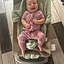 baby, smiling, infant, pink_outfit, baby_seat, blanket, floor_tiles, wooden_floor, foot, happy, indoors, person, child, cushion, home, cute, seated, infant_clothing, relaxed, playful