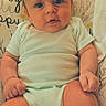 Mason is registered to the contest to win money with this photo: baby, infant, child, portrait, sitting, indoors, bed, pillow, blanket, onesie, clothing, face, eyes, hair, hands, legs, cute, awake, patterned_background, photography
