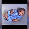 baby, child, infant, blue_clothing, smiling, lying_down, portrait, cute, young_child, short_hair, happy, indoor, casual, one_person, looking_at_camera, light_background, baby_boy, playful, small_feet, relaxed