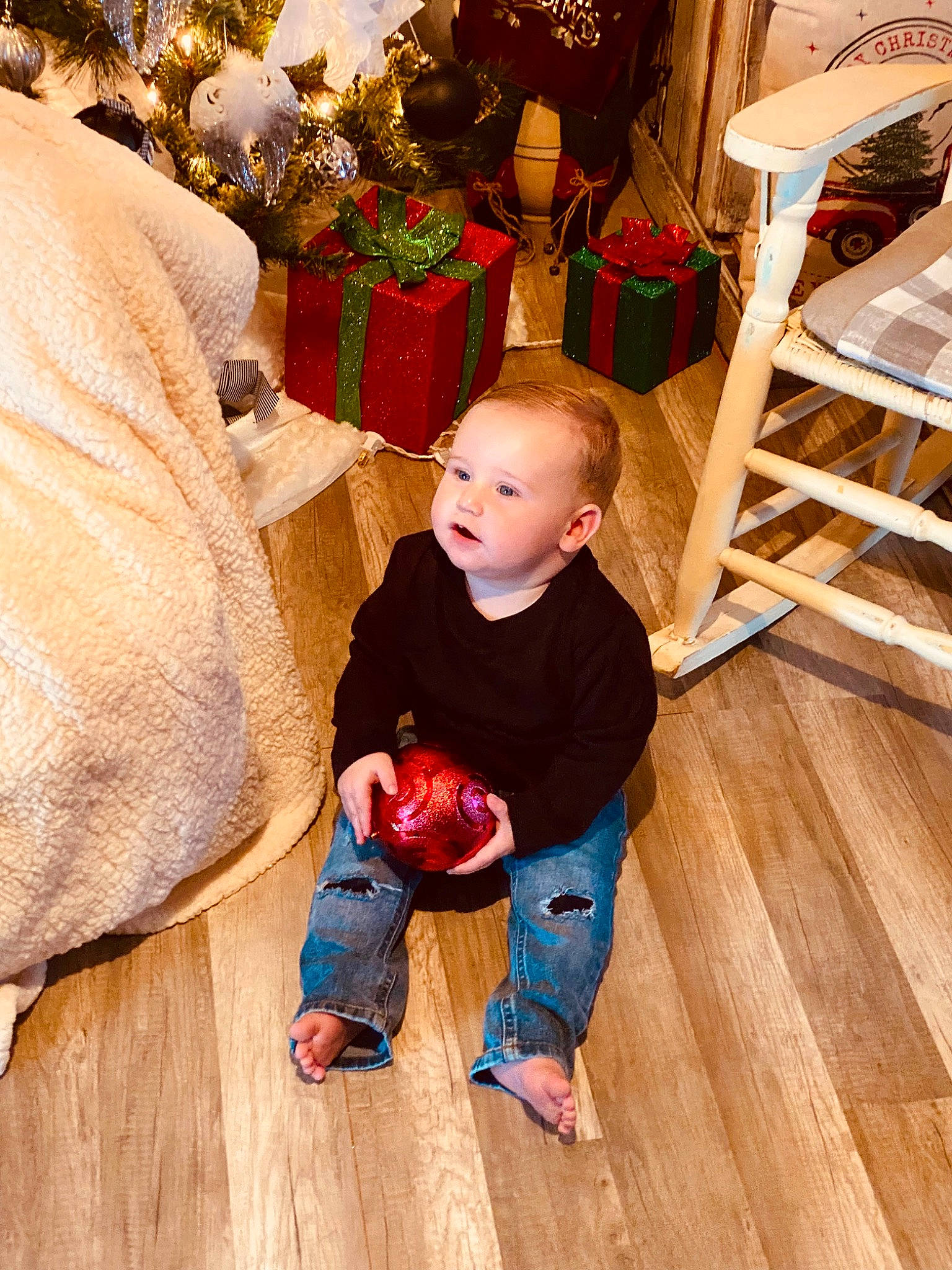 Aiden is registered to the contest to win money with this photo: baby_toddler_clothing, child, comfort, event, flooring, foot, fun, hardwood, laminate_flooring, lap, leg, leisure, living_room, person, sitting, toddler, tree, varnish, wood, wood_flooring