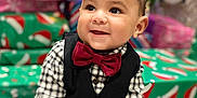 Anthony joined the competition — help win amazing prizes! baby, child, smiling, bow_tie, vest, plaid_shirt, christmas_tree, presents, holiday, decorations, indoors, festive, cute, sitting, portrait, happy, face, celebration, holiday_lighting, festive_clothing