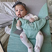 Amber Nicole joined the competition — help win amazing prizes! baby, infant, child, onesie, headband, tongue_out, baby_seat, comfybumppy, green, floral_pattern, sitting, indoor, bed, laptop, blanket, furniture, cute, expression, hand_grip, comfort
