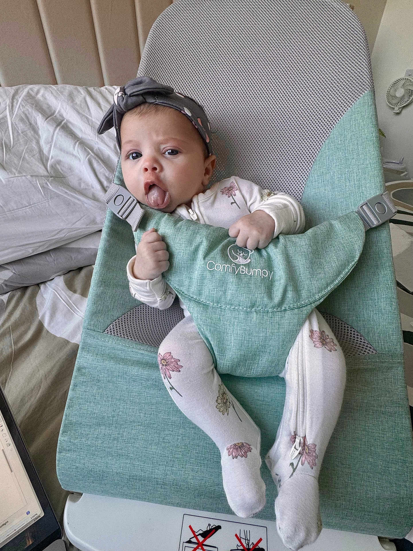 Amber Nicole joined the competition — help win amazing prizes! baby, infant, child, onesie, headband, tongue_out, baby_seat, comfybumppy, green, floral_pattern, sitting, indoor, bed, laptop, blanket, furniture, cute, expression, hand_grip, comfort