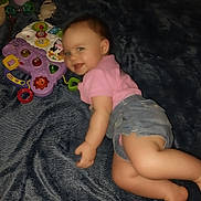 Freya joined the competition — help win amazing prizes! baby, child, smiling, pink_shirt, denim_shorts, toy, colorful_toy, blanket, indoor, happy, face, cute, infant, playful, young_child, lying_down, carpet, soft_texture, blue_blanket, portrait