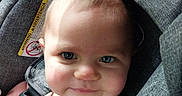 Freya is registered to the contest to win money with this photo: baby, infant, child, car_seat, automobile, portrait, smiling, blue_eyes, face, head, sitting, safety_harness, gray_upholstery, sunlight, indoor, vehicle, close_up, passenger, travel, adorable
