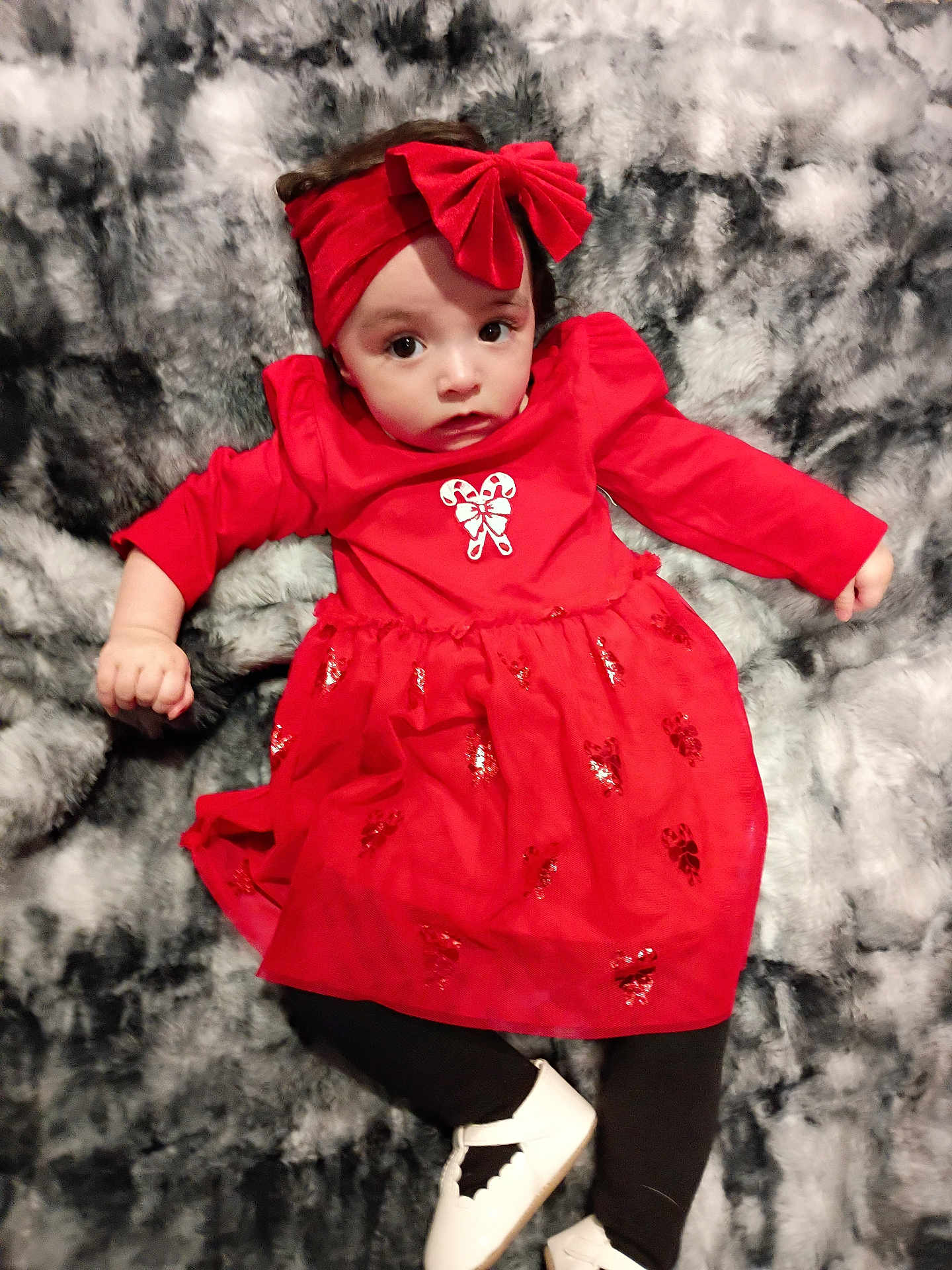 Mya joined the competition — help win amazing prizes! baby, child, red_dress, headband, bow, white_shoes, black_leggings, blanket, soft_texture, lying_down, indoors, cute, infant, portrait, holiday_clothing, expression, young_child, fashion, cozy, toddler