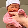 Tabitha is registered to the contest to win money with this photo: adult_arm, baby, being_held, close_up, closed_eyes, cradling, face, family, hat, hospital, indoors, infant, newborn, parent, photography, pink_clothing, portrait, sleeping, striped_hat, swaddled