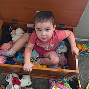 Melinda joined the competition — help win amazing prizes! carpet, child, colorful, curly_hair, expression, face, floor, indoors, mirror_toy, person, pink_clothing, playtime, plush_toys, socks, stuffed_animals, toddler, toy_chest, toys, wooden_furniture, xylophone