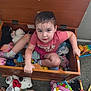 carpet, child, colorful, curly_hair, expression, face, floor, indoors, mirror_toy, person, pink_clothing, playtime, plush_toys, socks, stuffed_animals, toddler, toy_chest, toys, wooden_furniture, xylophone