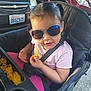 baby, car, casual, child, chips, daylight, face, food, hand, outdoor, parking_lot, person, pink_clothing, seat, seatbelt, smile, snack, stroller, sunglasses, toddler