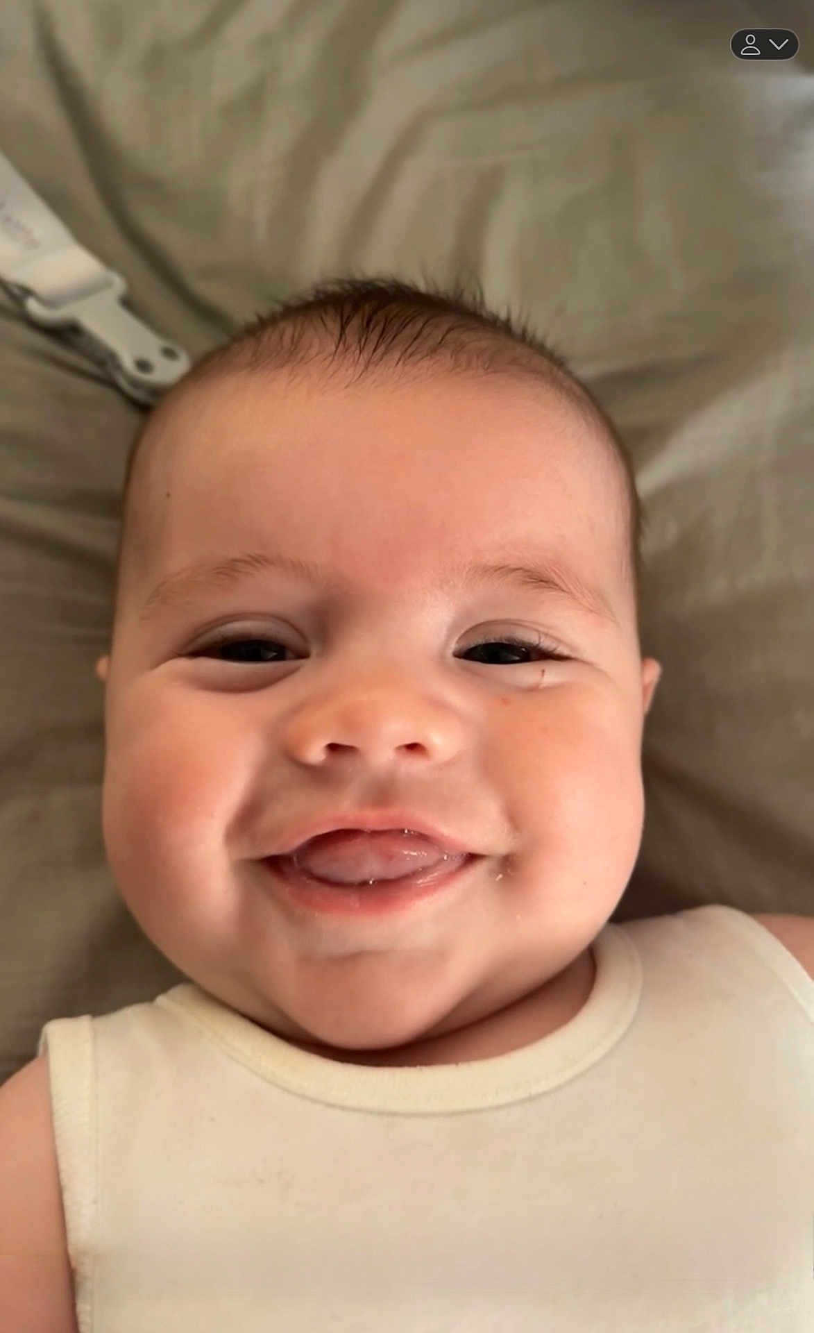 Luca Allan Hendrix is registered to the contest to win money with this photo: baby, smiling, face, tongue, chubby_cheeks, close_up, infant, cute, happy, white_clothing, lying_down, skin, head, eyes, mouth, expression, soft_background, indoor, person, child