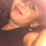 Koa is registered to the contest to win money with this photo: child, smile, face, dimple, close_up, selfie, blurry, black_shirt, arm, skin, indoors, warm_light, portrait, happy, young, casual, person, head, expression, fun