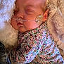 baby, sleeping, infant, face, oxygen_tube, blanket, floral_clothing, cozy, cute, child, skin, head, peaceful, resting, indoors, soft_texture, newborn, healthcare, closeup, person