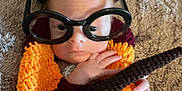 Larry is registered to the contest to win money with this photo: baby, child, glasses, knit_blanket, orange, brown, carpet, indoor, closeup, face, hand, cozy, novelty_glasses, infant, cute, expression, person, portrait, warm, soft