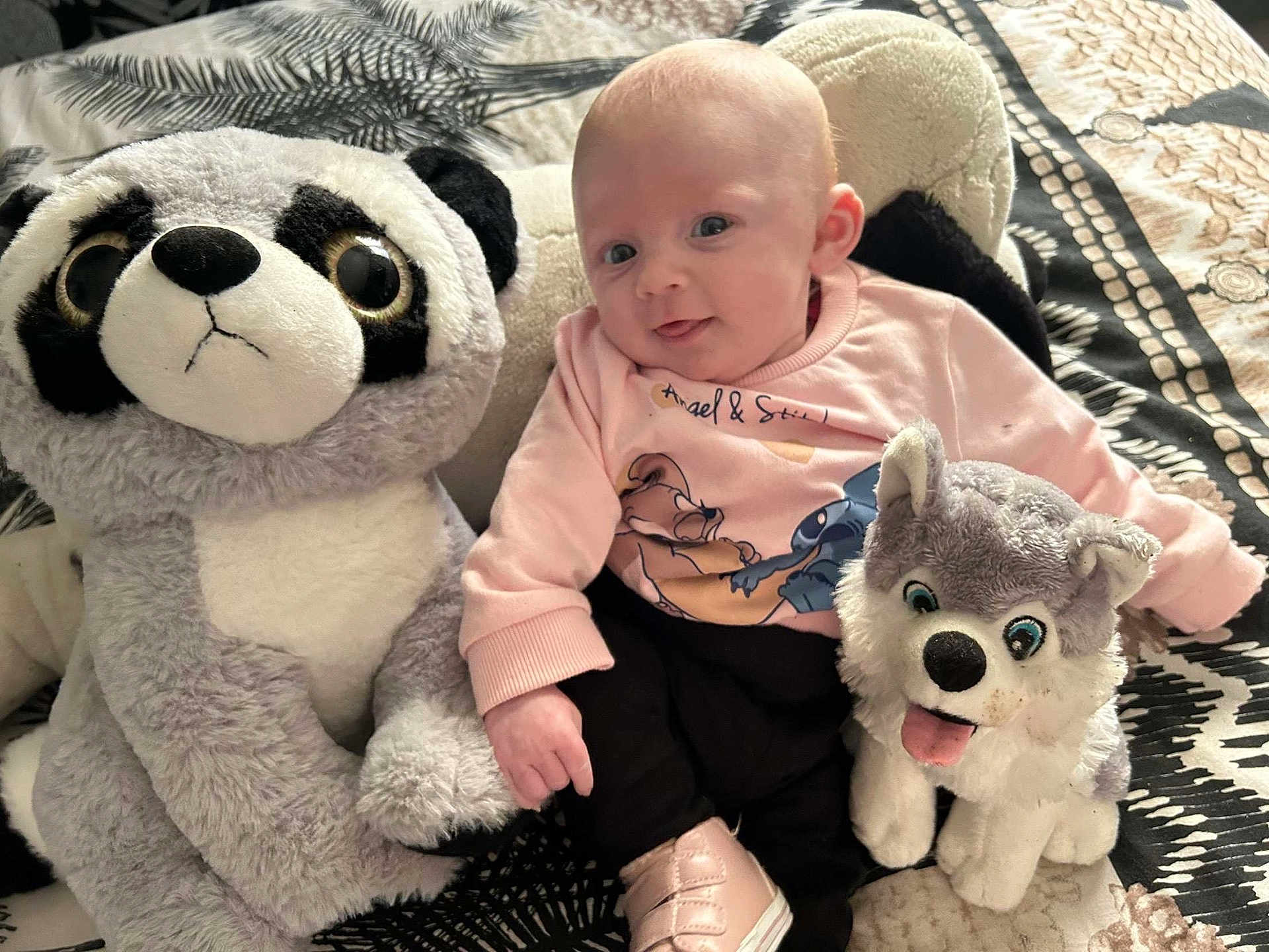 Catalyna a rejoint le concours — aidez-le/la à gagner de superbes lots ! baby, child, stuffed_animal, panda, husky, plush_toy, pink_clothing, black_pants, bedspread, patterned_bed, smiling, indoor, cute, soft_toys, footwear, toy, person, sitting, infant, cozy