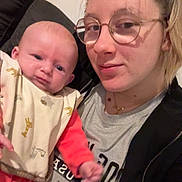 Catalyna participe au concours pour gagner de l'argent avec cette photo : baby, adult, glasses, bib, couch, indoor, person, portrait, clothing, face, young_adult, infant, expression, casual, home, seated, blanket, jacket, tshirt, hair