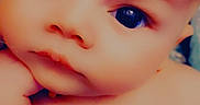 Ash is registered to the contest to win money with this photo: baby, close_up, face, child, expression, eyes, skin, blanket, pattern, colorful, infant, portrait, cute, young, hand, soft_lighting, indoors, person, head, skin_texture
