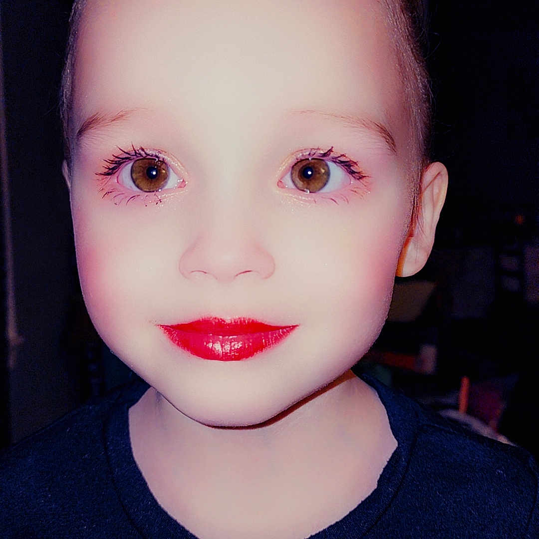 Annalisa is registered to the contest to win money with this photo: bright_lighting, brown_eyes, casual_clothing, child, childhood, closeup, dark_background, expressionless, eyelashes, face, head, indoor, innocence, light_skin, lipstick, makeup, person, portrait, tshirt, young