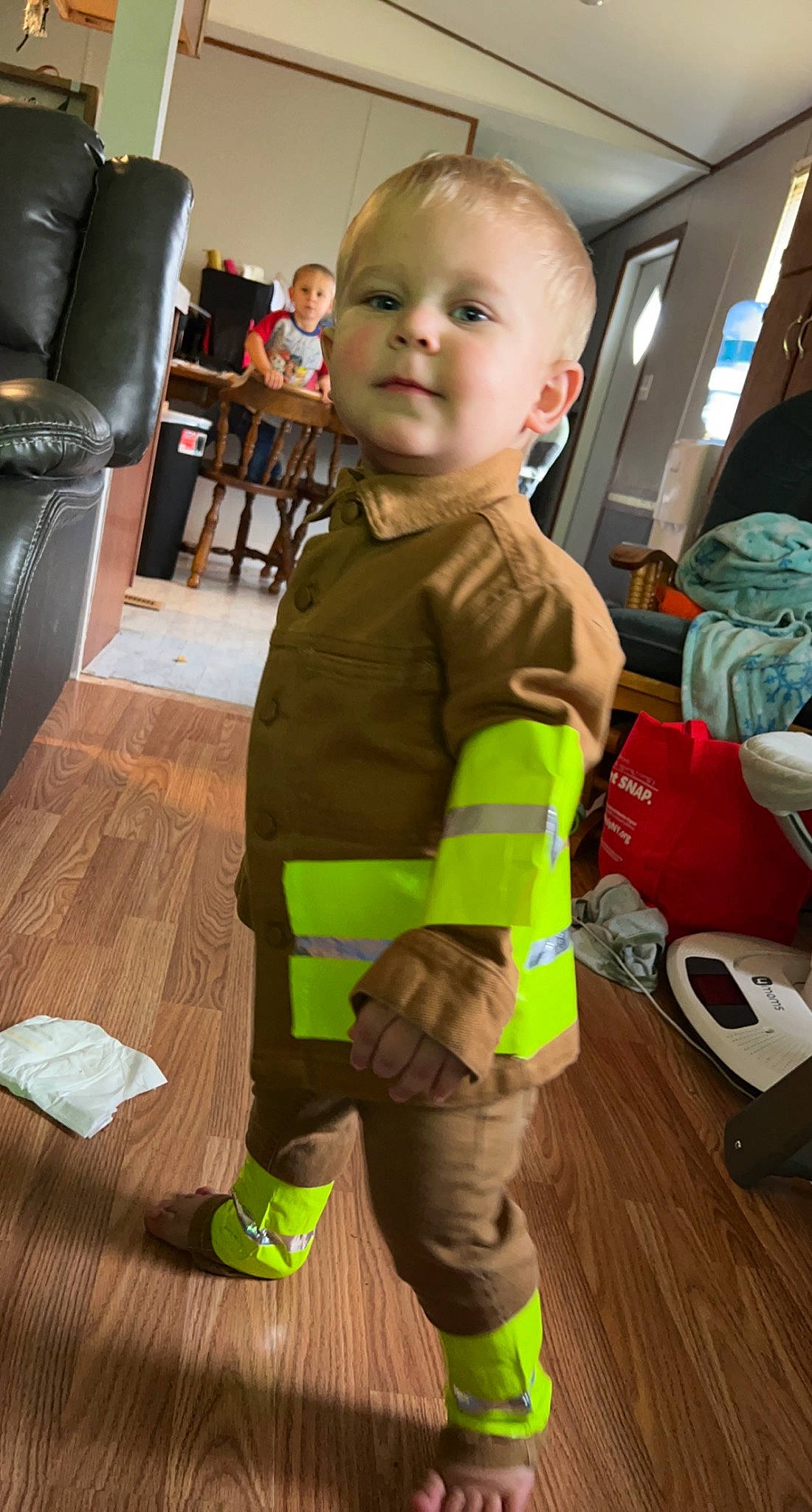 Brody joined the competition — help win amazing prizes! baby, chair, child, costume, fictional_character, floor, flooring, fun, hardwood, high_visibility_clothing, laminate_flooring, person, personal_protective_equipment, play, room, sitting, sock, toddler, wood, wood_flooring