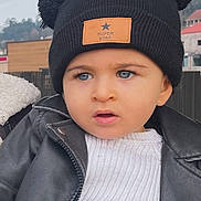 Rodrigo participe au concours pour gagner de l'argent avec cette photo : toddler, child, blue_eyes, black_hat, pom_poms, super_star_patch, white_sweater, black_jacket, outdoor, portrait, curious_expression, winter_clothing, face, headwear, cute, young_child, fashion, person, close_up, casual