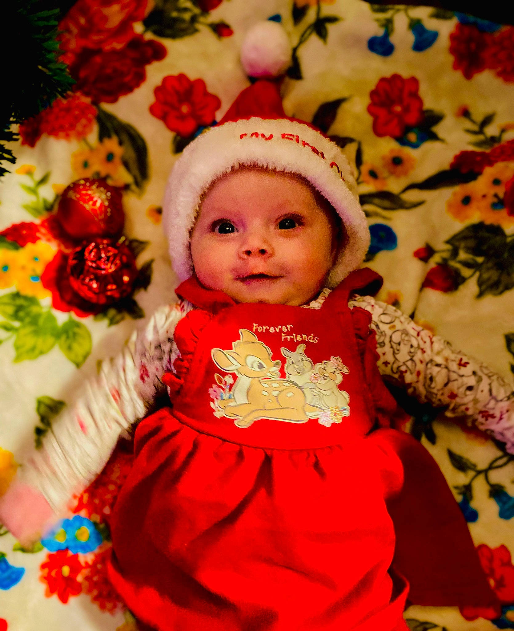 Marceline is registered to the contest to win money with this photo: baby, baby_toddler_clothing, child, cut_flowers, dress, event, facial_expression, happy, headwear, magenta, orange, pattern, peach, people_in_nature, person, petal, pink, rose_family, skin, sweetness
