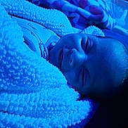 Kaylani is registered to the contest to win money with this photo: baby, blanket, blue_light, smile, cozy, sleepy, child, soft_texture, warm, face, portrait, indoor, cute, infant, wrapped, sleeping, peaceful, young, comfort, zipped_clothing