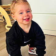 éva a rejoint le concours — aidez-le/la à gagner de superbes lots ! black_sweatshirt, blue_eyes, cabinet, child, crawling, cute, flooring, furniture, hair_ties, happy, indoor, nike, person, pigtails, pink_toothbrush, smiling, sneakers, toddler, wooden_floor, young